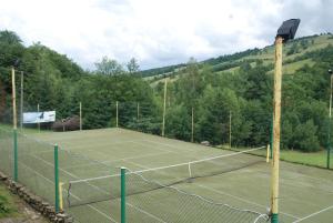 a tennis court with a net on top of it at Apartamenty pod Werchowyną in Chyrowa