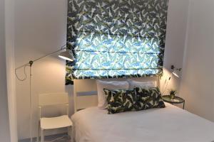 een slaapkamer met een bed en een raam erboven bij Braga centro - apartamento espaçoso e confortável - Todas as comodidades in Braga