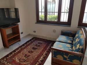 a living room with a couch and a television at la maison de rêve in Camaiore