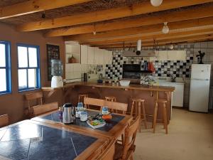 a large kitchen with a wooden table and chairs at Andes Nomads Desert Camp & Lodge in San Pedro de Atacama