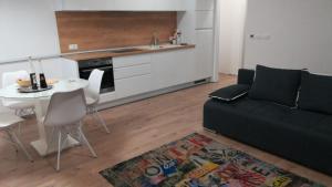 a living room with a couch and a table and a kitchen at Centar Guest house in Makarska