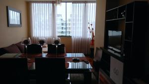 Sala de estar con mesa de comedor y TV en Kennedy Park 601 Apartment, en Lima