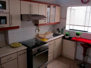 una pequeña cocina con fogones y fregadero en Kennedy Park 601 Apartment, en Lima