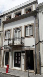 een gebouw met een balkon erboven bij Nas Três Janelas in Viana do Castelo