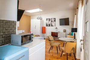 a kitchen with a microwave and a table with chairs at Villa Koffi Apartments 16 plus in Puck