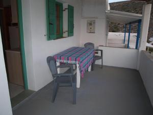 a table and chairs on a balcony with a table and a window at Kokagia House in Cherronisos