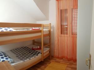 a room with two bunk beds and a door at Apartman Vojaline in Milna +26 photos