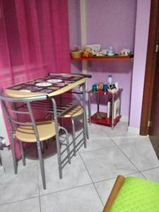 einen Tisch und Stühle in einem Zimmer mit rosa Vorhängen in der Unterkunft La Corte dei Morra in Venafro