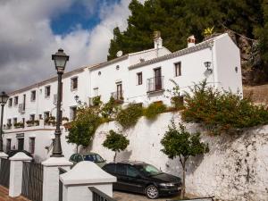 a white building with a car parked in front of it at El Buen Sitio in Zahara de la Sierra