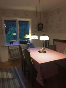 a dining room with a table with chairs and lights at Kolstigenhus in Fågelfors