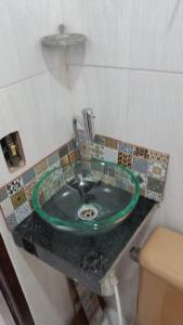 lavabo con grifo verde en la encimera en Flat - Arraial do Cabo - Praia Grande, en Arraial do Cabo