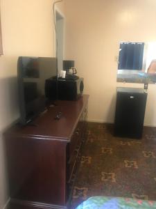 Habitación con escritorio, TV y cama. en Lone Pine Motel, en Garberville