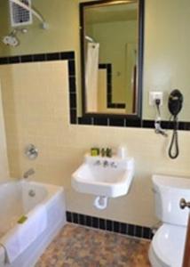 uma casa de banho com um lavatório, um WC e um espelho. em The Murray Hotel em Silver City