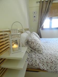a bedroom with a bed with a candle on it at Oceanos in Costa da Caparica