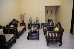 a living room with black chairs and a table at Rumah Eyang Guest House in Banyuwangi