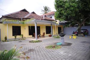 a house with a courtyard in front of it at Rumah Eyang Guest House in Banyuwangi