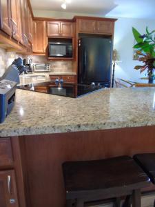 a kitchen with a granite counter top and a kitchen island at Aloha KAI - Resort Condo in Kihei