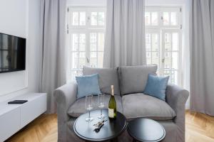 - un salon avec un canapé et une table avec des verres à vin dans l'établissement Gdansk Old Town ul. Sw. Ducha 68 Apartments, à Gdańsk