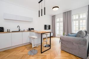 une cuisine et un salon avec un canapé et une table dans l'établissement Gdansk Old Town ul. Sw. Ducha 68 Apartments, à Gdańsk
