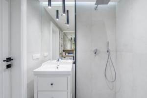 une salle de bain blanche avec lavabo et douche dans l'établissement Gdansk Old Town ul. Sw. Ducha 68 Apartments, à Gdańsk 24 autres photos