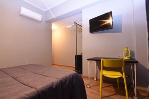 una camera con letto, tavolo e sedia gialla di Turiddu B&B a Catania