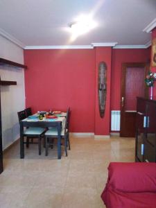 a dining room with red walls and a table and chairs at Cabañaquinta Senderista in Aller +28 photos