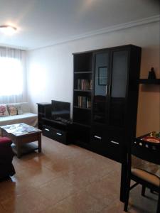 a living room with a black book shelf and a couch at Cabañaquinta Senderista in Aller