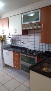 a kitchen with a sink and a stove top oven at Cantinho da Paz in Brasília