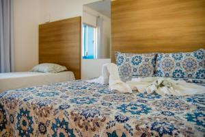 a bedroom with a bed with a blue and white blanket at Pousada Ilha do Sol in Morro de São Paulo