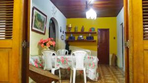 a dining room with a table and white chairs at Praieiro Hostel Albergue in Parnaíba
