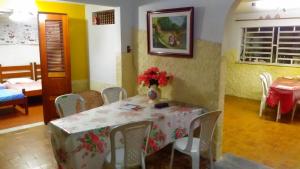 a dining room with a table with a vase on it at Praieiro Hostel Albergue in Parnaíba