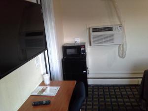 a hotel room with a table and a microwave and a microwave at Economy Inn Tonawanda in Tonawanda