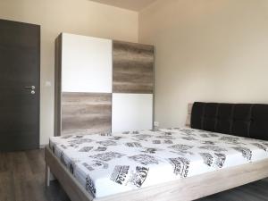 een slaapkamer met een groot bed met een houten hoofdeinde bij Exclusive Home in Pécs