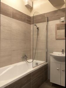 a bathroom with a bath tub and a sink at Exclusive Home in Pécs