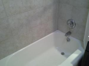 a white bath tub in a bathroom at Economy Inn Tonawanda in Tonawanda