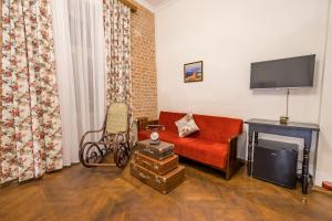 a living room with a red couch and a tv at Doors Meidan Design Hotel in Tbilisi City