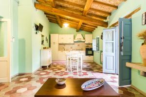 cocina con paredes verdes y techo de madera en Antica Dimora del Melograno, en Nurachi