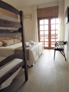 1 dormitorio con 2 literas y ventana en Casa Piedra Hotel en Villa Carlos Paz