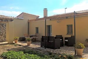 un patio con sillas y una mesa frente a una casa en Antica Dimora del Melograno en Nurachi