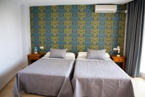 Łóżko lub łóżka w pokoju w obiekcie Hotel Salambina