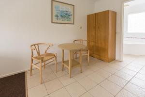 a kitchen with a table and two chairs and a cabinet at Fox on the Run - Motel Kilmore in Kilmore