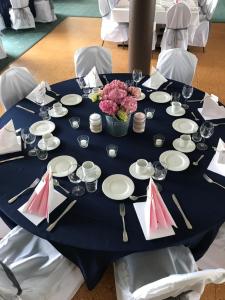 a blue table with white plates and flowers on it at Sogn Hotel in Vadheim