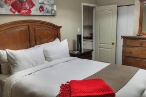 a bedroom with a white bed with a red blanket on it at 1-Bedroom Cozy #18 by Amazing Property Rentals in Gatineau