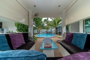 sala de estar con sofá, mesa y piscina en Coconut Palms, en Kantharawichai