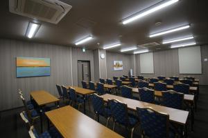 uma sala de conferências com mesas e cadeiras em Hotel Route-Inn Sendai Higashi em Sendai