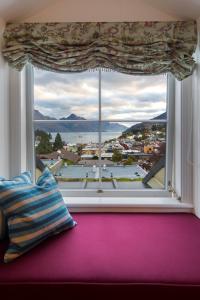 a large window with a view of a city at Hulbert House Luxury Boutique Lodge Queenstown in Queenstown