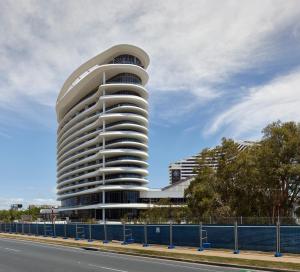 a building with a circular facade on the side of a road at The Darling at The Star Gold Coast in Gold Coast