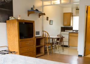 a kitchen with a refrigerator, stove, sink and a television at Dreamers Lodge in John Day