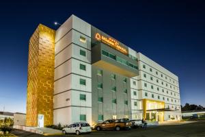 un edificio di un hotel con auto parcheggiate di fronte di Mision Express Durango a Durango