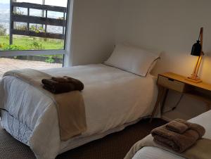 a bedroom with a bed with towels on it at Aorangi Highland Country Retreat in Rotorua